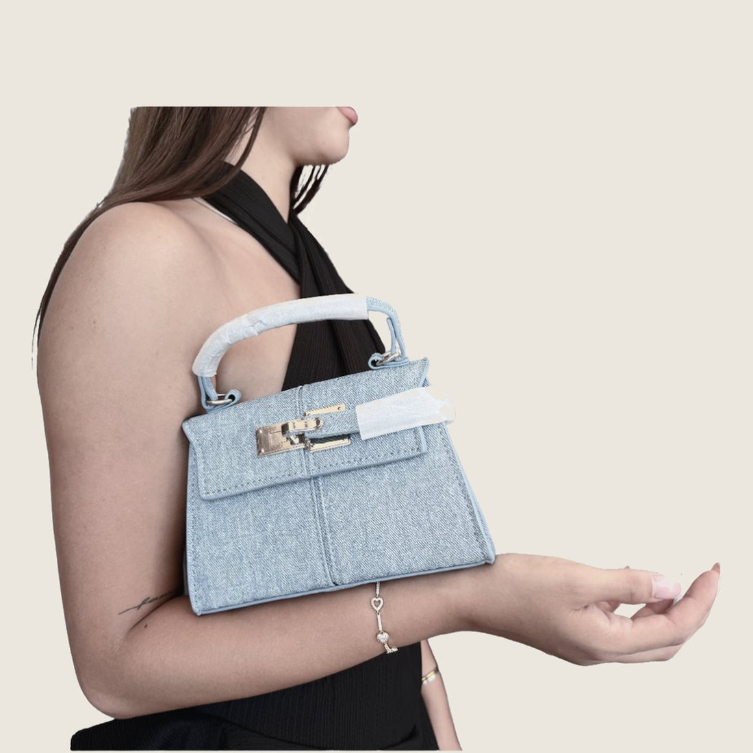 Model kolunda mavi denim mini çanta taşırken